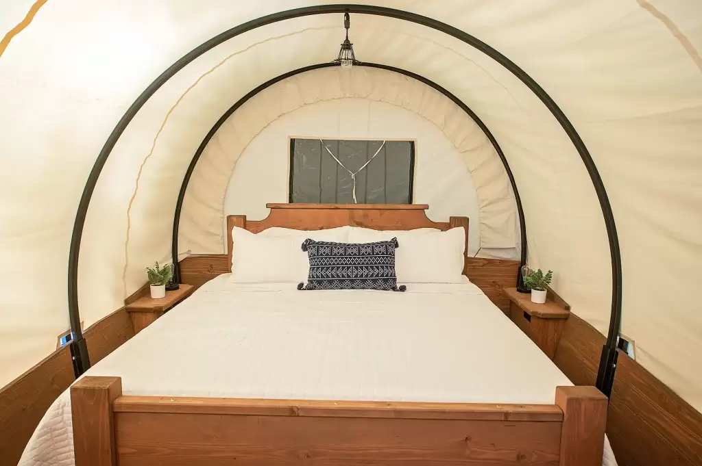 king sized bed in a glamping wagon on the Ocoee River